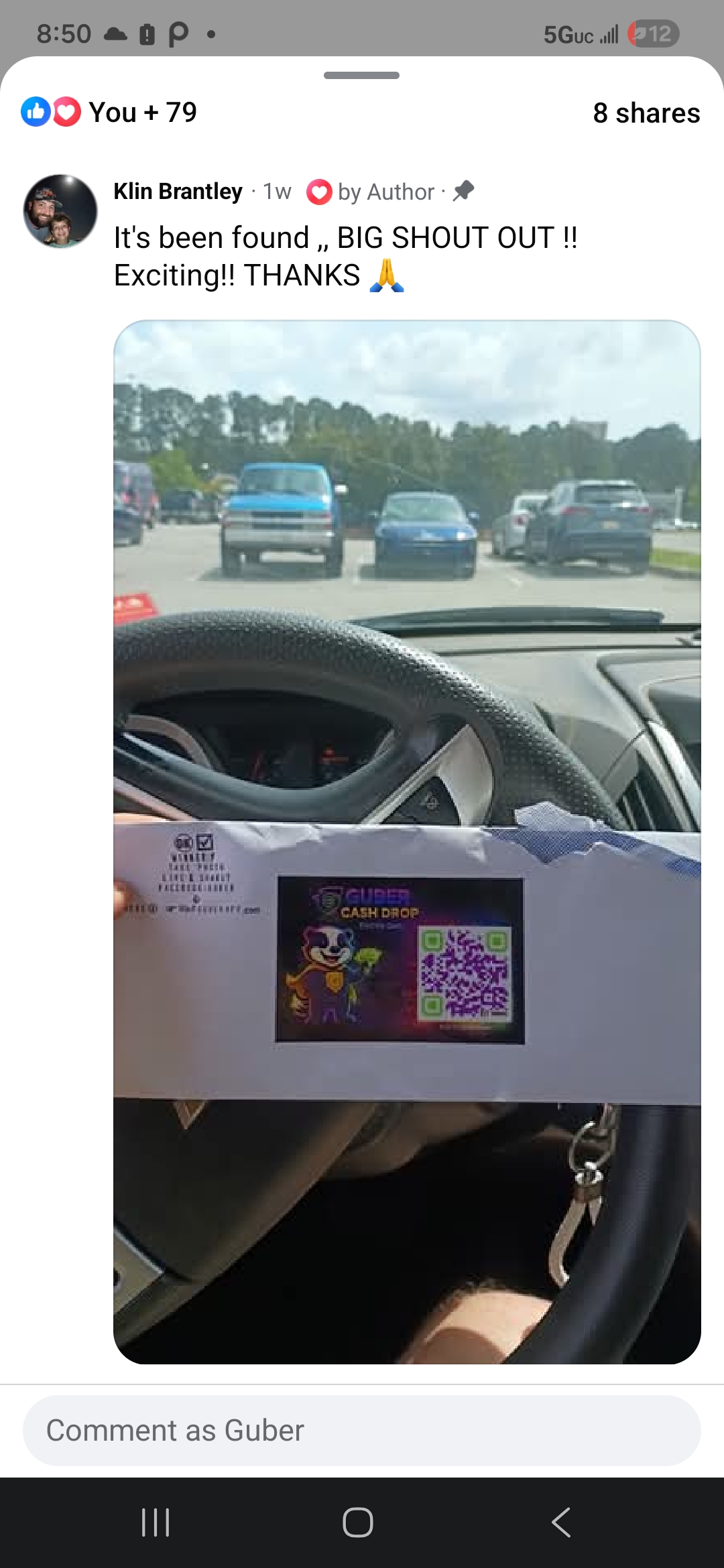 Klin Brantley holding a GUBER Cash Drop card on the steering wheel